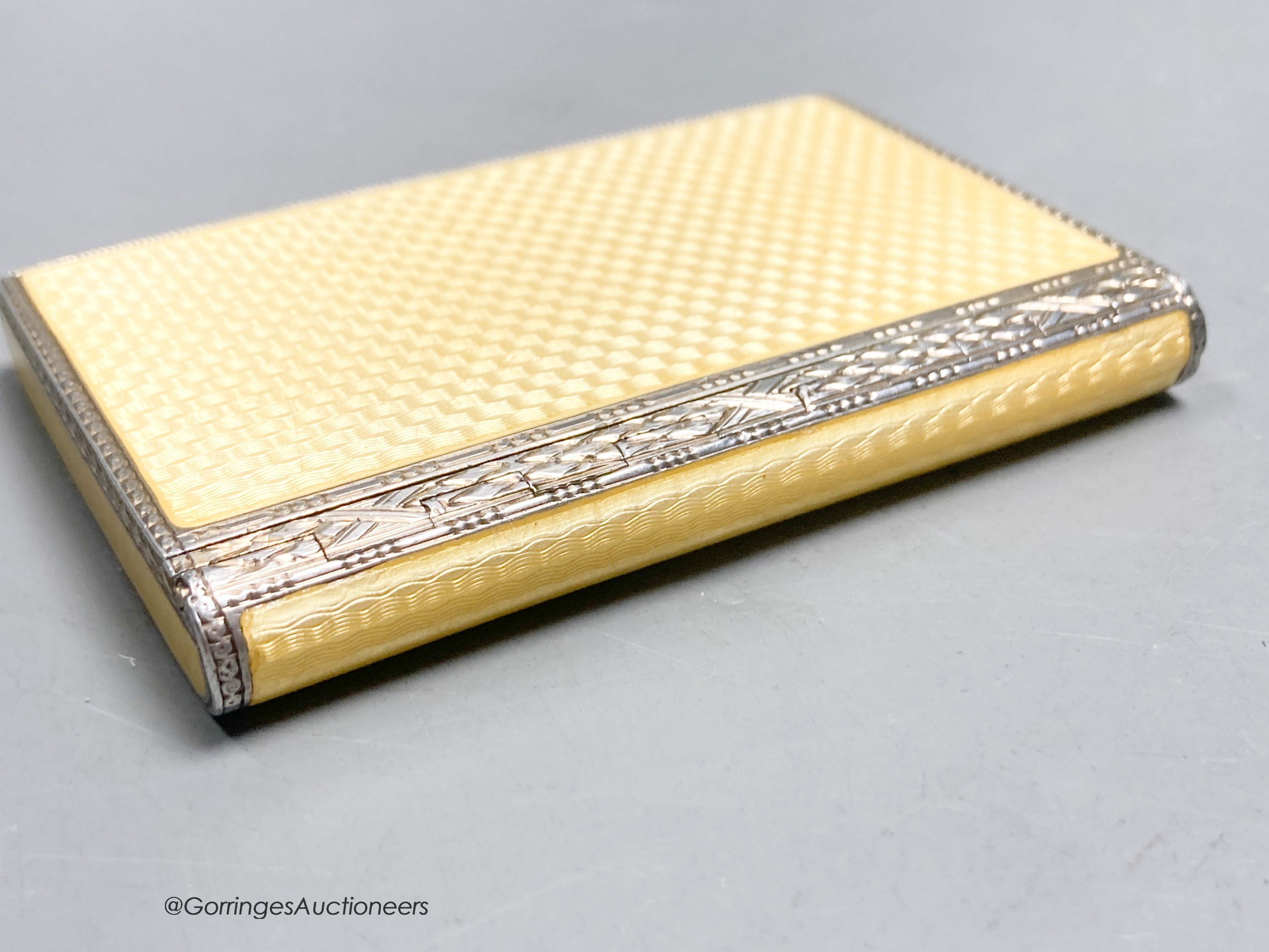 A 1920's continental silver and yellow guilloche enamel rectangular box and hinged cover, import marks for P.H. Vogel & Co, London, 1927, 79mm by 53mm by 10mm